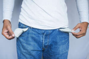 Eine Person zeigt ihre leeren Hosentaschen.