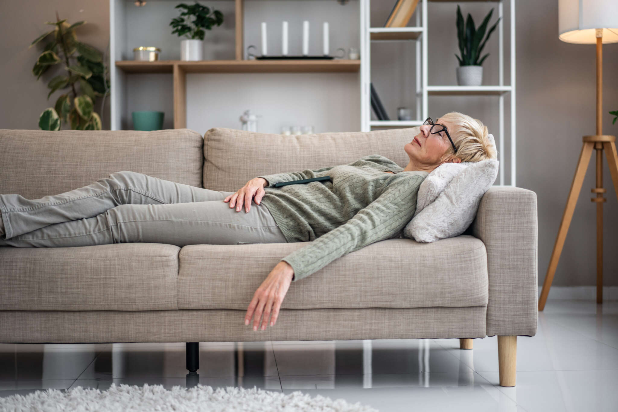 Eine Frau liegt auf einem Sofa.