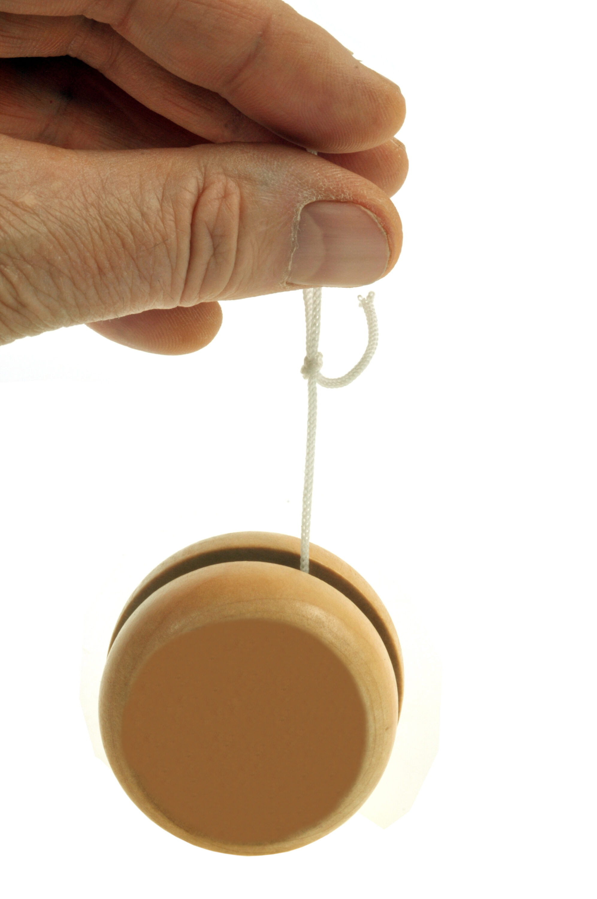 Nahaufnahme einer Hand mit einem Jojo vor weißem Hintergrund